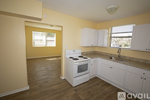 A kitchen with white appliances and cabinets is available for rent.