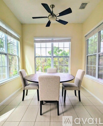 A dining room with a table and chairs.