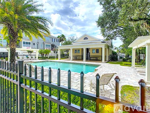 A house with a pool and a fence in front of it.