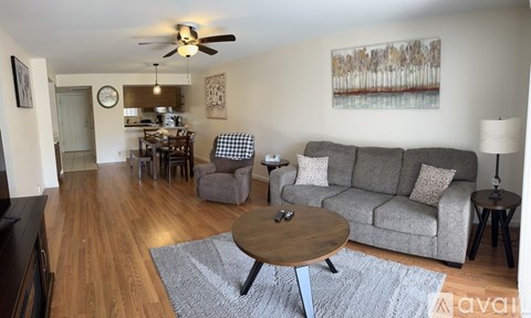 A living room with a grey couch, a coffee table, and a ceiling fan.