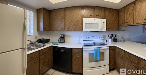A kitchen with wooden cabinets and white appliances.