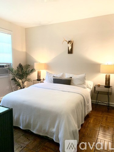 A bedroom with a large bed and two lamps.