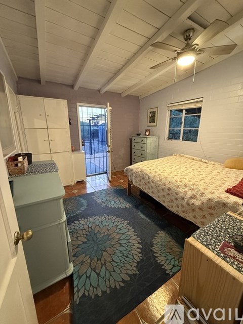 A bedroom with a bed, dresser, and ceiling fan.