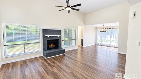 A living room with a fireplace and a ceiling fan.