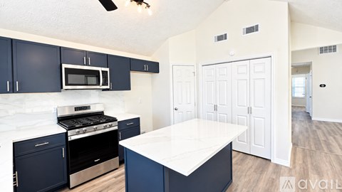 A kitchen with dark blue cabinets and a white countertop.