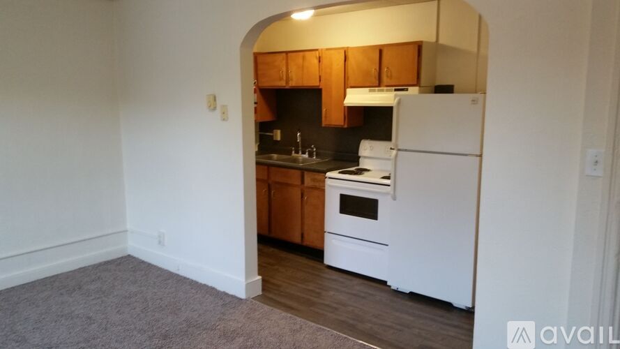 A kitchen with white appliances and wooden cabinets.