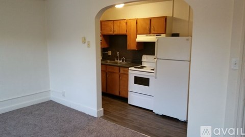 A kitchen with white appliances and wooden cabinets.