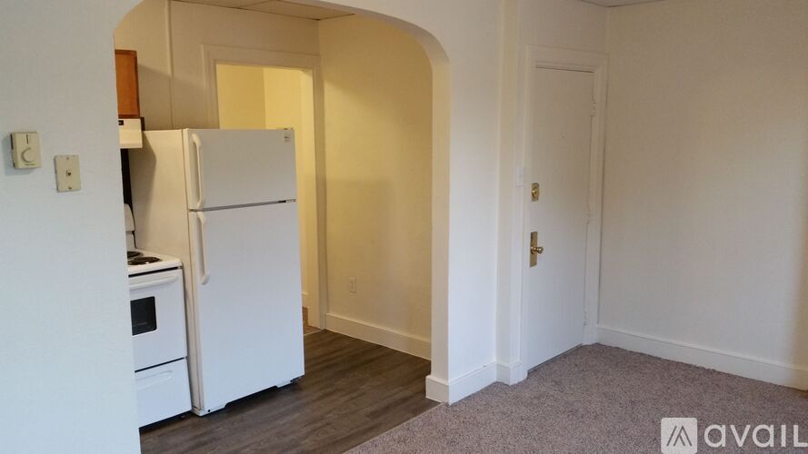 A kitchen with a white fridge and a white door.