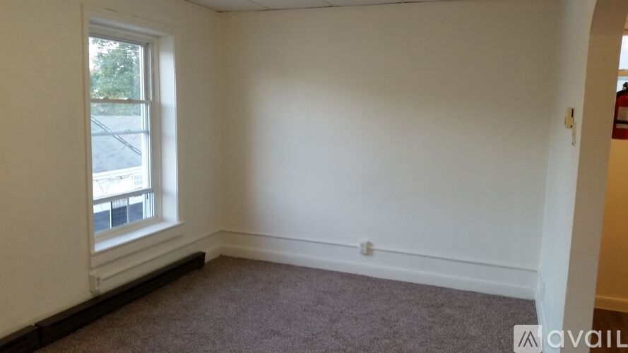 A room with a window and carpeted floor.