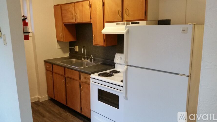 A white refrigerator is in a kitchen with wooden cabinets.