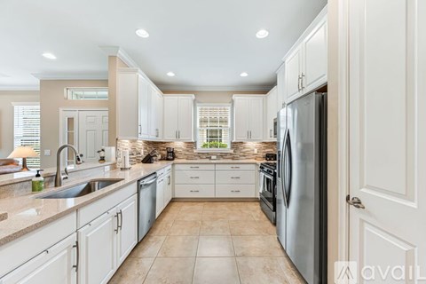 A kitchen with white cabinets and a tiled floor.