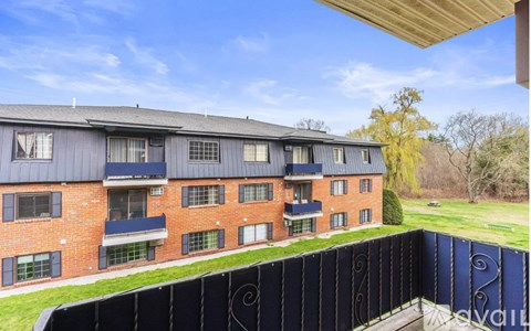 A red brick building with a black fence in front.
