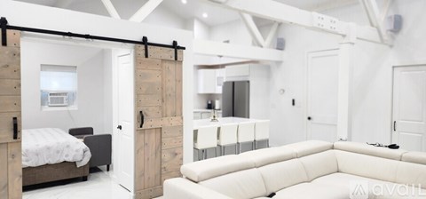 A bedroom with a bed and a couch in it.