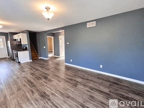 A spacious room with wooden flooring and a light on the ceiling.