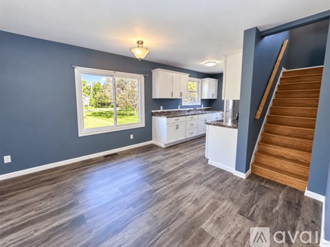 A spacious living room with a staircase leading to the upper floor.