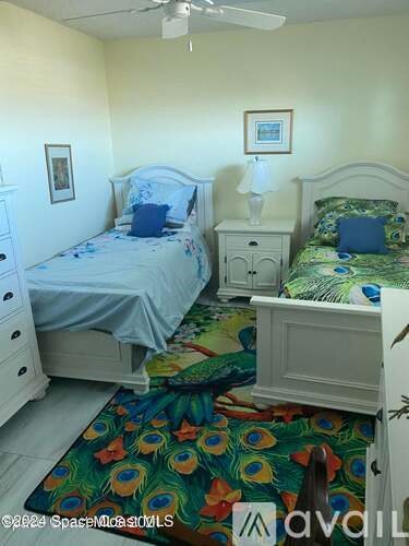 A bedroom with two beds and a dresser.