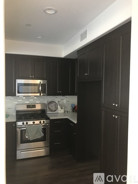 A kitchen with dark wood cabinets and stainless steel appliances.