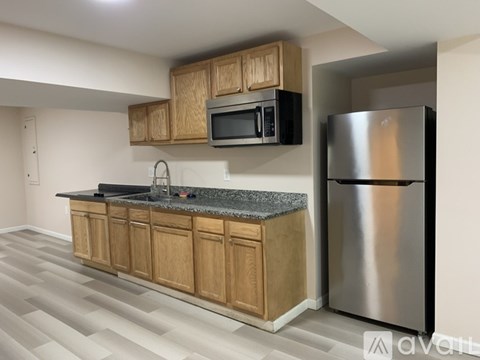 A kitchen with wooden cabinets and a stainless steel refrigerator.