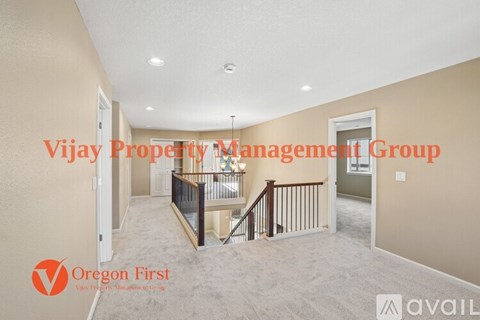 A spacious room with a staircase and a window, managed by Vijay Property Management Group.