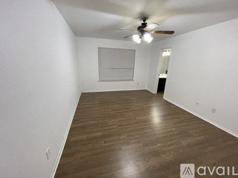 A room with wooden flooring and a ceiling fan.