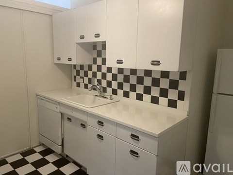 A white kitchen with black and white checkered floor.