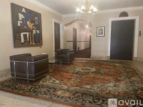 A living room with a large rug and a painting on the wall.