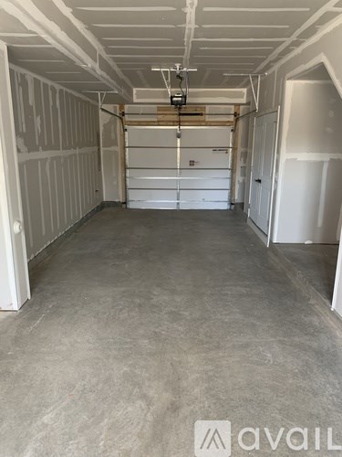 A spacious room with a white ceiling and walls, and a concrete floor.