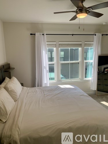 A bedroom with a large bed and a ceiling fan.