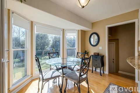 A dining room with a glass table and chairs.