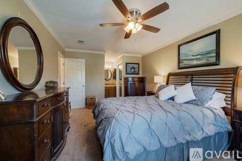 A bedroom with a large bed and a ceiling fan.