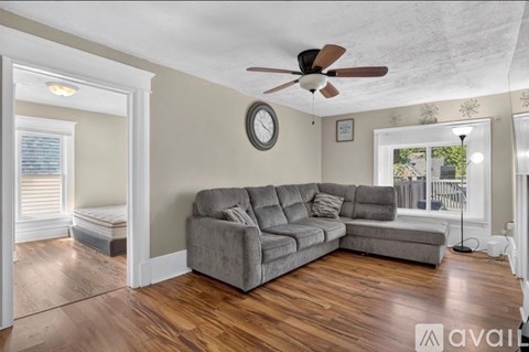 A living room with a grey sectional sofa and a ceiling fan.