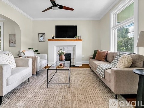 A living room with a fireplace, two couches, and a television.