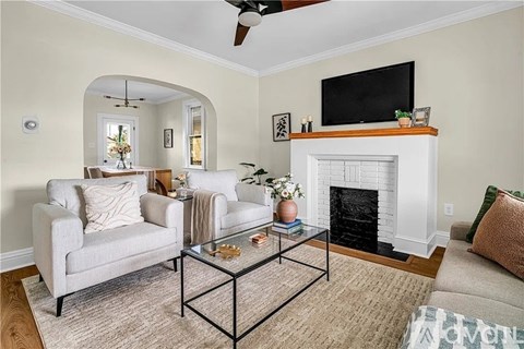 A living room with a fireplace, a chair, a sofa, and a television.
