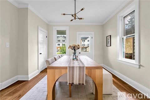 A dining room with a wooden table and chairs.