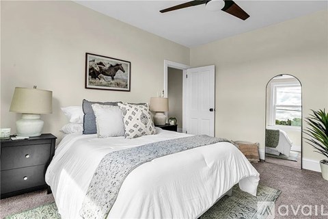 A bedroom with a large bed and a ceiling fan.