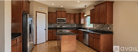 A kitchen with wooden cabinets and a granite countertop.