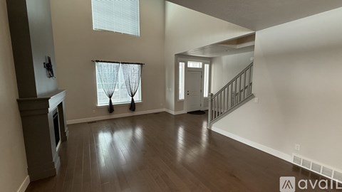 A spacious living room with a fireplace and hardwood floors.