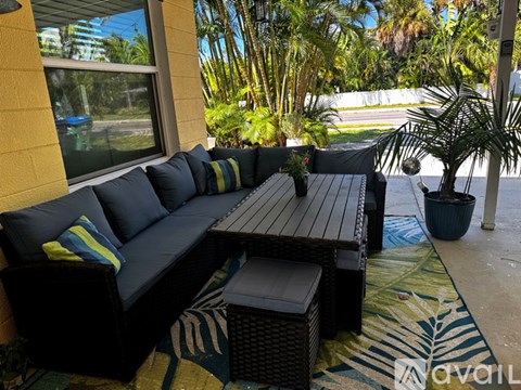 A patio with a black sofa and a table.