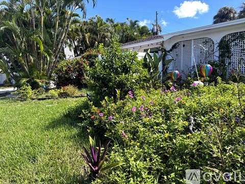 A garden with a variety of plants and flowers in the foreground.