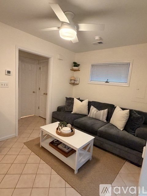 A living room with a grey couch and a white coffee table.