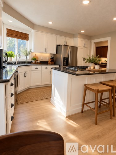 A kitchen with white cabinets and a black countertop.