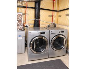 Two front loading washing machines in a laundry room.