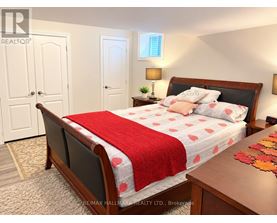 A bedroom with a bed covered in a red and white bedspread.