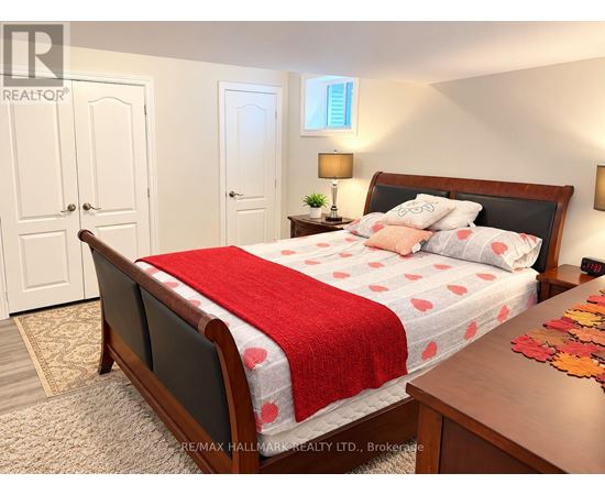 A bedroom with a bed covered in a red and white bedspread.