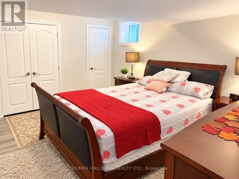A bedroom with a bed covered in a red and white bedspread.