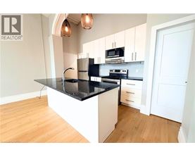 A modern kitchen with a black countertop and white cabinets.
