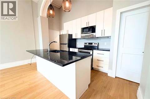 A modern kitchen with a black countertop and white cabinets.