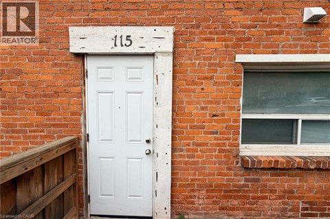 A white door with the number 115 above it.