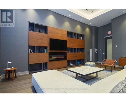 A modern bedroom with a large bed and a wooden entertainment center.