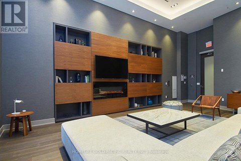 A modern bedroom with a large bed and a wooden entertainment center.